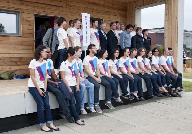 Student team with matching tshirts sits together on the porch of the Empowerhouse.
